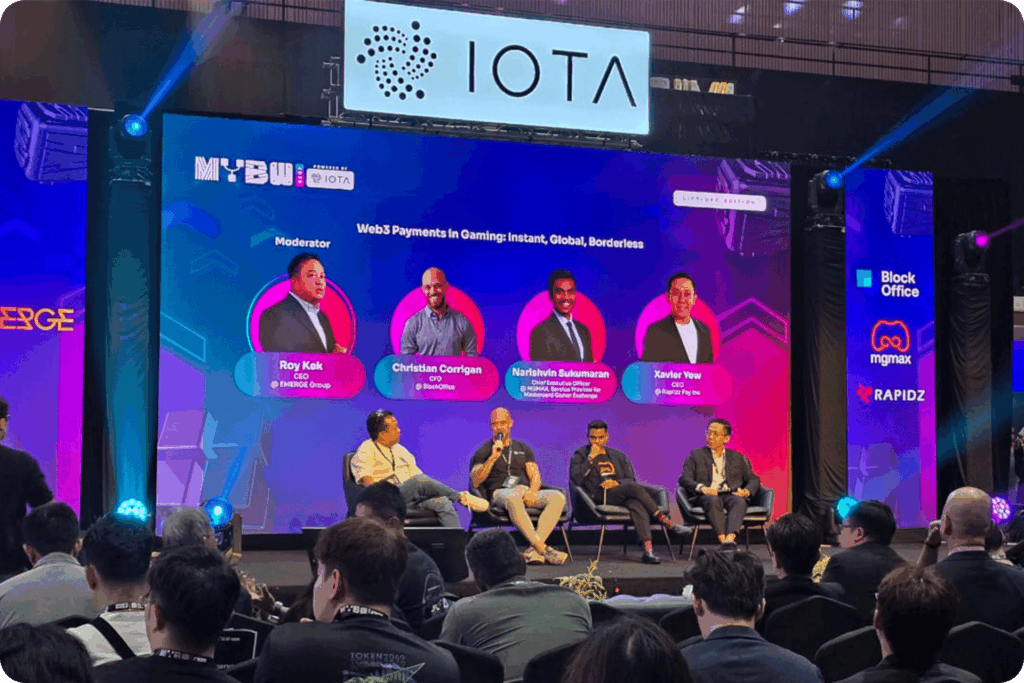 A group photo of the panel on gaming payments at Malaysia Blockchain Week 2025, with moderator and speakers on stage.